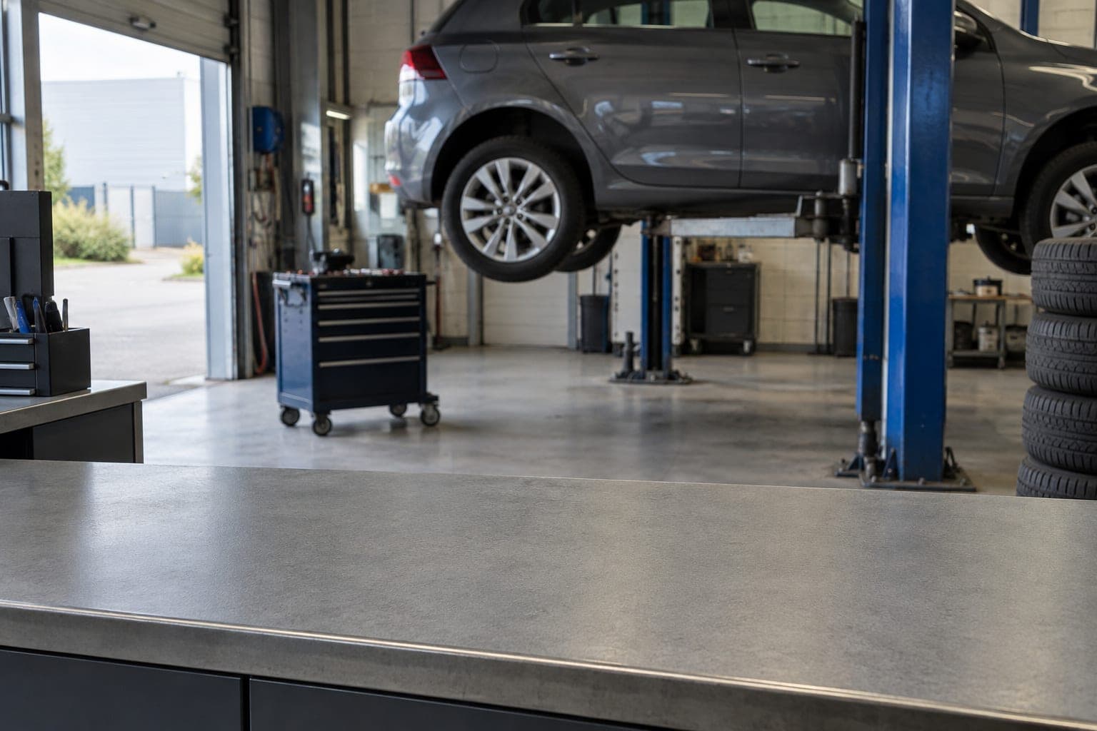 Lege servicebalie in een autowerkplaats, met een auto op de hefbrug op de achtergrond